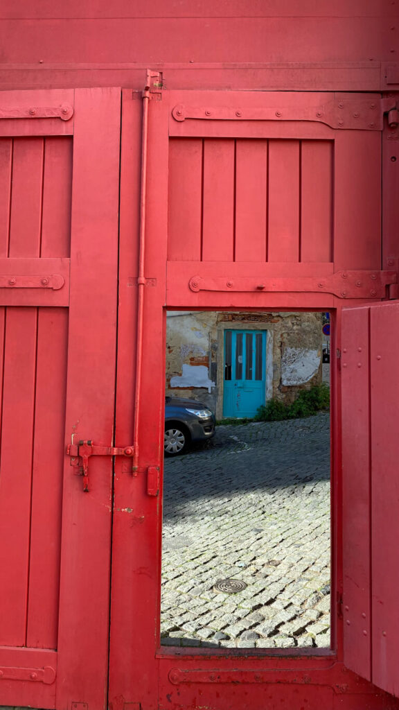 view of a street in alfama through a framed gate