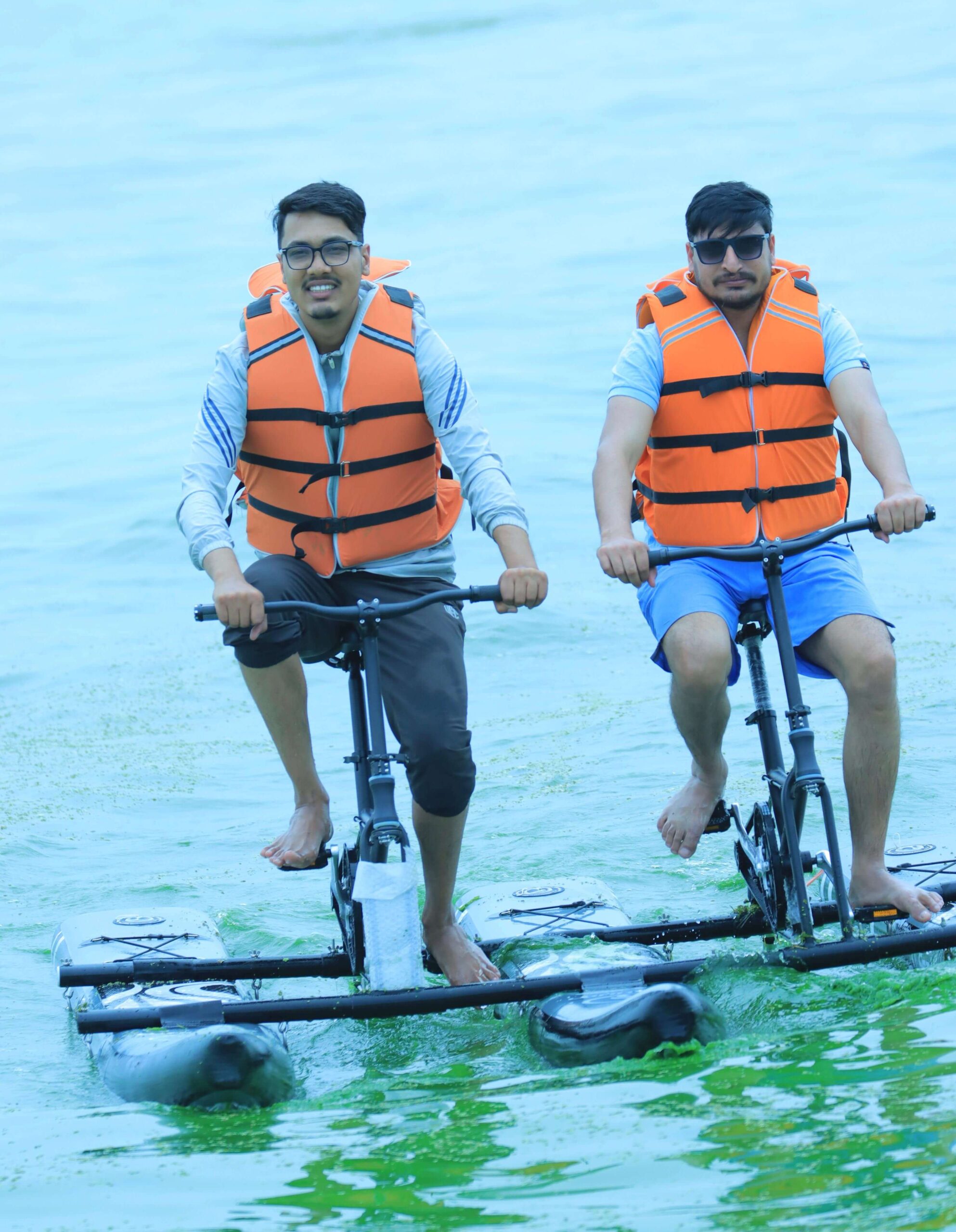 two boys water cycling together in a pond